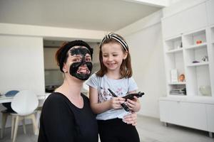 mère et fille à la maison faisant un traitement de beauté au masque facial photo