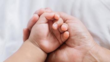 gros plan la main de bébé sur les mains de la mère photo