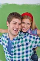 couple heureux peindre un mur dans une nouvelle maison photo