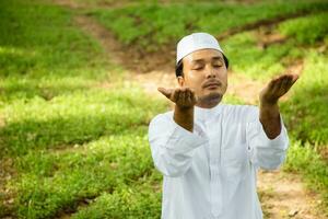 homme musulman asiatique priant allah dieu de l'islam tout en levant les bras, concept du festival du ramadan photo
