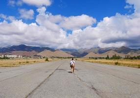 homme vu de dos alors qu'il marche sur un aérodrome abandonné photo