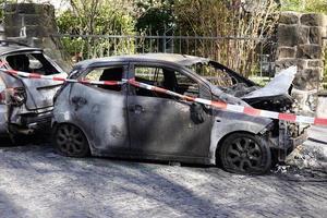 Des épaves de voitures brûlées derrière une bande de police dans une rue résidentielle en Allemagne photo