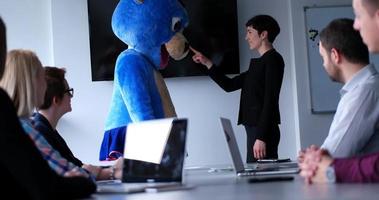 patron habillé en ours s'amusant avec des gens d'affaires dans un bureau branché photo