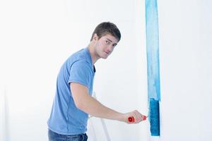 beau jeune homme peinture mur blanc en couleur photo