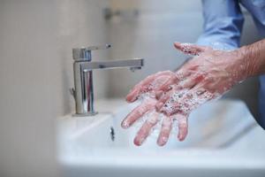 coronavirus mâle se laver les mains dans la salle de bain photo