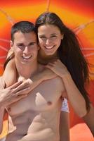 heureux jeune couple s'amuser sur la plage photo