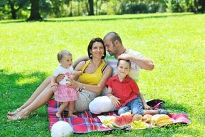 heureux jeune couple avec leurs enfants s'amuser au parc photo