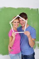 couple heureux peindre un mur dans une nouvelle maison photo