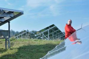 ingénieur utilisant un ordinateur portable sur le terrain de l'usine de panneaux solaires photo