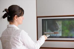 jeune femme regardant la télé à la maison photo