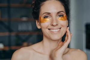 heureuse fille européenne faisant des procédures de spa et touche la peau de son visage. détente et soins de la peau. photo