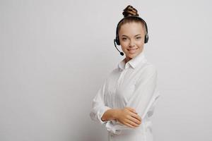 agent de centre d'appels féminin avec casque noir et bras croisés photo