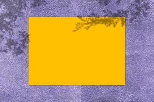 maquette d'affiche carrée jaune vide avec ombre légère sur fond de mur de béton violet. photo