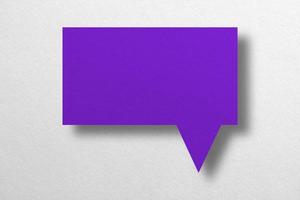 forme de ballon de discours découpé en papier violet isolé sur fond blanc photo
