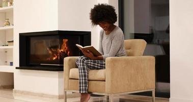 femme noire à la maison lisant un livre photo