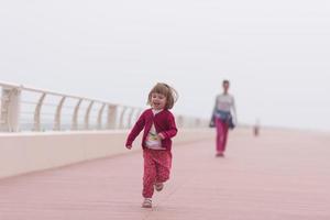 mère et jolie petite fille sur la promenade au bord de la mer photo