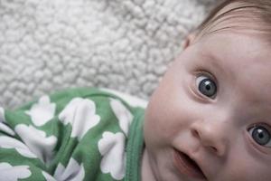 mignon petit bébé jouant avec les mains et souriant photo