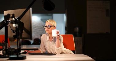 femme travaillant sur ordinateur dans un bureau sombre photo