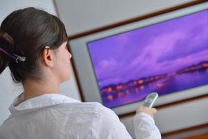 jeune femme regardant la télé à la maison photo