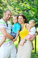 heureux jeune couple avec leurs enfants s'amuser au parc photo