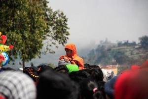 dieng, indonésie - 1er août 2015. festival de la culture dieng, les touristes suivent la procession des dreadlocks lors de l'événement du festival de la culture dieng à dieng, district de banjarnegara, java central photo