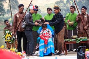 dieng, indonésie - 1er août 2015. festival de la culture dieng, les touristes suivent la procession des dreadlocks lors de l'événement du festival de la culture dieng à dieng, district de banjarnegara, java central photo