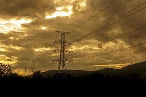 coucher de soleil derrière la silhouette des pylônes électriques - effet de couleurs vives photo