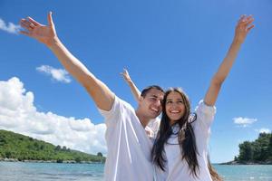 heureux jeune couple s'amuser sur la plage photo