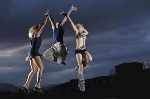 groupe de personnes sautant dans les airs la nuit photo