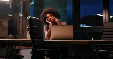 femme d'affaires noire à l'aide d'un ordinateur portable dans le bureau de démarrage de nuit photo