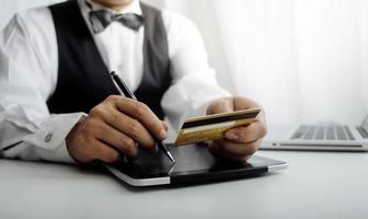 concept de technologie, de personnes et d'achats en ligne - homme souriant heureux avec ordinateur tablette et carte de crédit à la maison photo