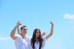 heureux jeune couple s'amuser sur la plage photo