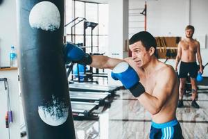 boxeur avec sac de boxe en salle de sport photo