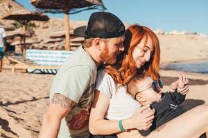 les parents passent du temps avec leur fils sur la plage photo