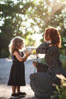 maman et petite fille avec une rose jaune photo