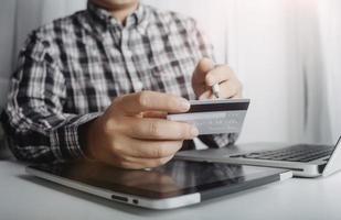 concept de technologie, de personnes et d'achats en ligne - homme souriant heureux avec ordinateur tablette et carte de crédit à la maison photo