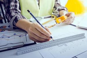 Deux collègues discutant des données de travail et tablette, ordinateur portable avec sur le projet architectural sur le chantier de construction au bureau au bureau photo