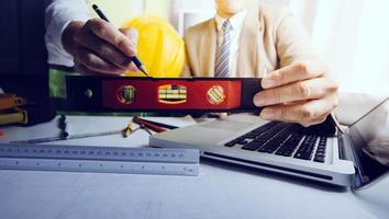 Deux collègues discutant des données de travail et tablette, ordinateur portable avec sur le projet architectural sur le chantier de construction au bureau au bureau photo