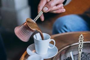 la main de l'homme verse du café dans une tasse photo