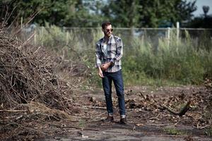 l'homme aux bottes authentiques et aux jeans selvedge sur fond de branches photo