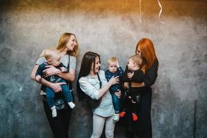 trois mamans avec leurs enfants posant devant la caméra photo