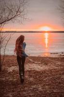 femme appréciant le temps de détente au bord du magnifique lac au lever du soleil. photo