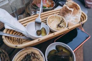 délicieux houmous frais, pain pita et concombres cornichons photo