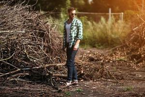 l'homme aux bottes authentiques et aux jeans selvedge sur fond de branches photo