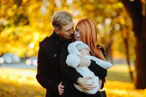 jeune famille et fils nouveau-né dans le parc d'automne photo