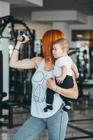 jeune mère avec son jeune fils dans la salle de gym photo