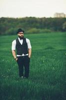 un homme avec une barbe et des lunettes de soleil marchant sur le terrain photo