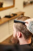 coiffeur masculin professionnel travaille avec un peigne photo