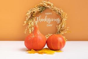 message texte joyeux thanksgiving day avec collection de citrouilles d'automne avec couronne sur fond orange blanc. carte de voeux photo