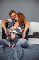 famille heureuse avec bébé nouveau-né sur le lit photo